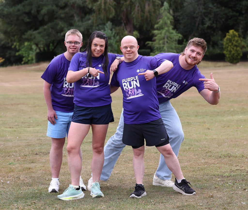 Picture of adults and adults with Down syndrome in a park with Rugby star Joe McCarthy in Purple t-shirts