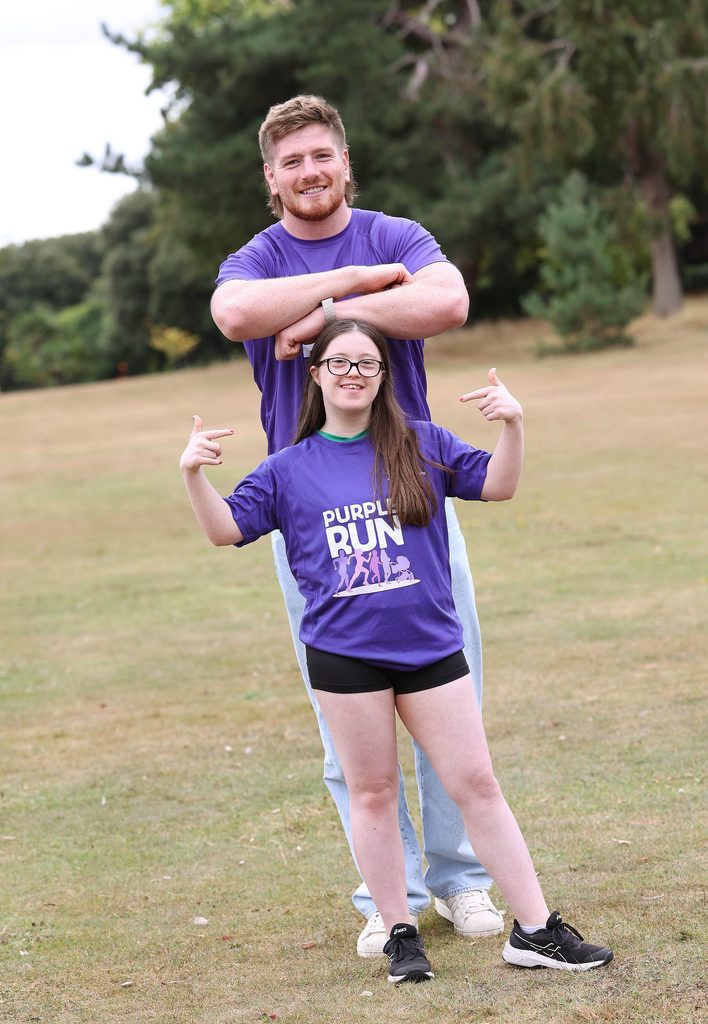 Picture of a lady with Down syndrome in a park with Rugby star Joe McCarthy in Purple t-shirts